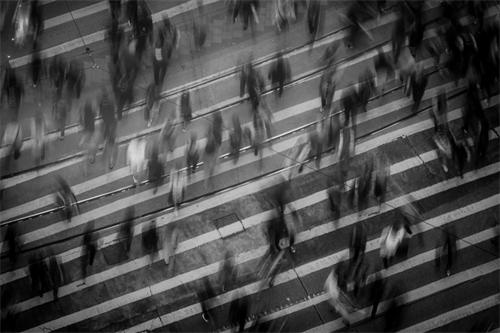 Aerial view of blurred pedestrians crossing a city intersection