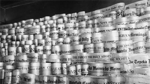 A wall made of tightly packed rolled-up newspapers