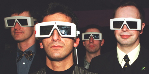 A group of men wearing early model 3D shutter glasses