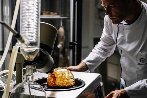 A chef using distillation equipment to prepare a culinary creation